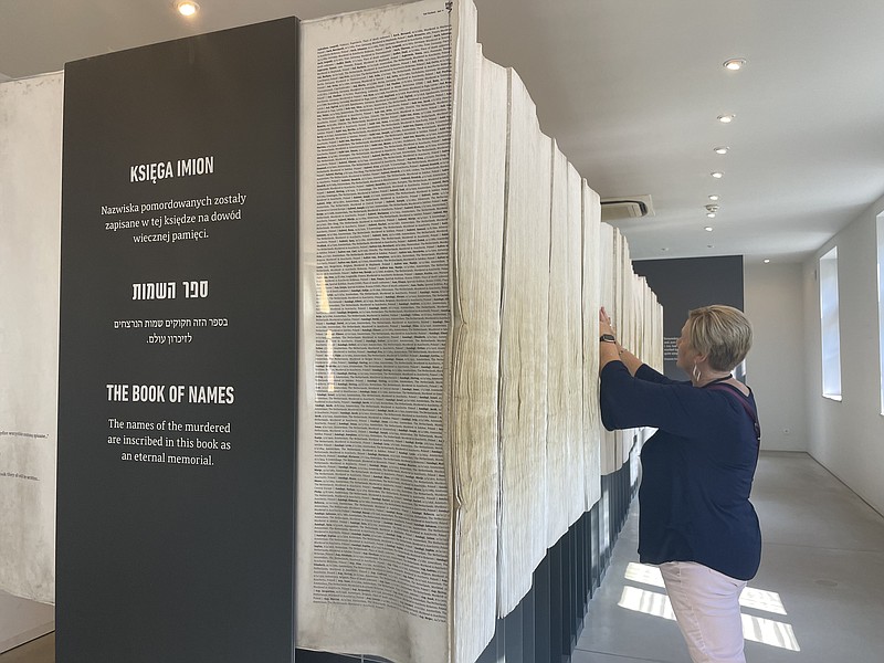 Submitted photo courtesy of Helias Catholic
Helias Catholic teacher Kathy Jarman leafs through pages of the Book of Names in Auschwitz I, which lists the known names of those killed during the Holocaust. Jarman found the name Jarman in the book.