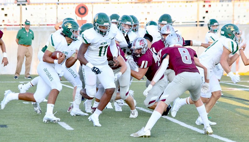 Mark Ross/Special to the Herald-Leader
Alma quarterback Joe Trusty (left) carries the ball with a host of blockers in front as Siloam Springs defenders try to make the stop. The Airedales defeated the Panthers 38-7.