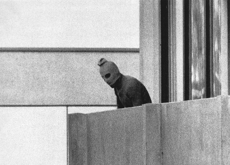 FILE - A member of the Arab Commando group which seized members of the Israeli Olympic Team at their quarters at the Olympic Village appearing with a hood over his face stands on the balcony of the building where the commandos held members of the Israeli team hostage in Munich, Sept. 5, 1972. The families of 11 Israeli athletes killed by Palestinian attackers at the 1972 Summer Olympics in Munich and the German government are close to reaching a deal over the long-disputed amount of the compensation. (AP Photo/Kurt Strumpf, File)