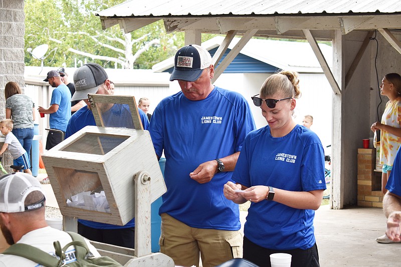 Isaac Imhoff, left, Mike Toellner, center, and Madison Imhoff prepare for a raffle Monday (Sept. 5, 2022,) during the Jamestown Labor Day Celebration in Jamestown Lions Club Park. The Jamestown Lions Club raffled a 50-inch smart television. (Democrat photo/Garrett Fuller)