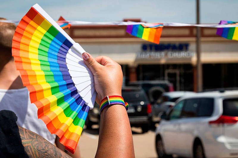 A No Hate in Texas protester holds up a fan while protesting Stedfast Baptist Church in July 2022 in Watauga, Texas. (Yffy Yossifor/Fort Worth Star-Telegram/TNS)