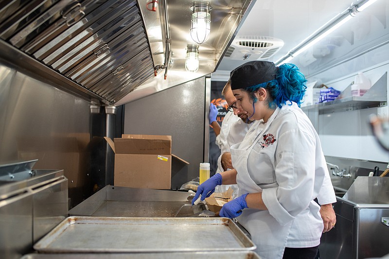 Iliana Osuna grills ribeye steak as Culinary Arts Academy Executive Chef Cory House inside the school’s new food truck Thursday, Sept. 8, 2022, at Texas High School in Texarkana, Texas. The purchase of the food truck was made using Career Technical Education program federal funds to give students real-world application. Students served street tacos with a side of Mexican corn. (Staff photo by Erin DeBlanc)