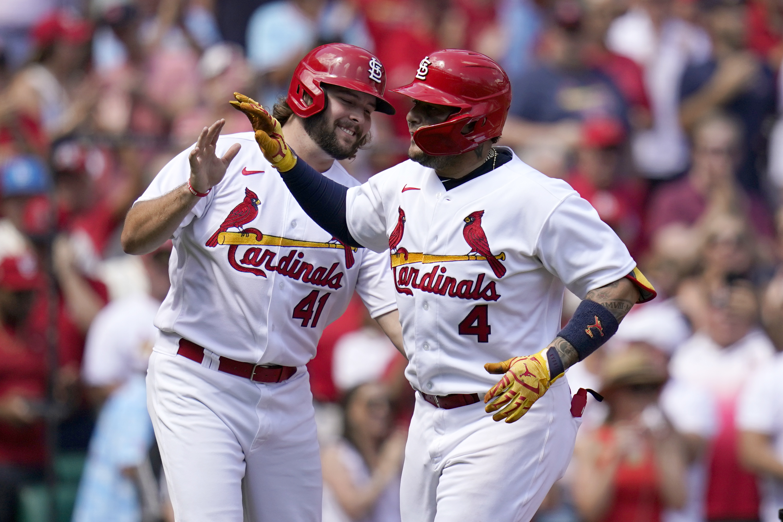 St. Louis Cardinals' Yadier Molina (4) gets a hug from former