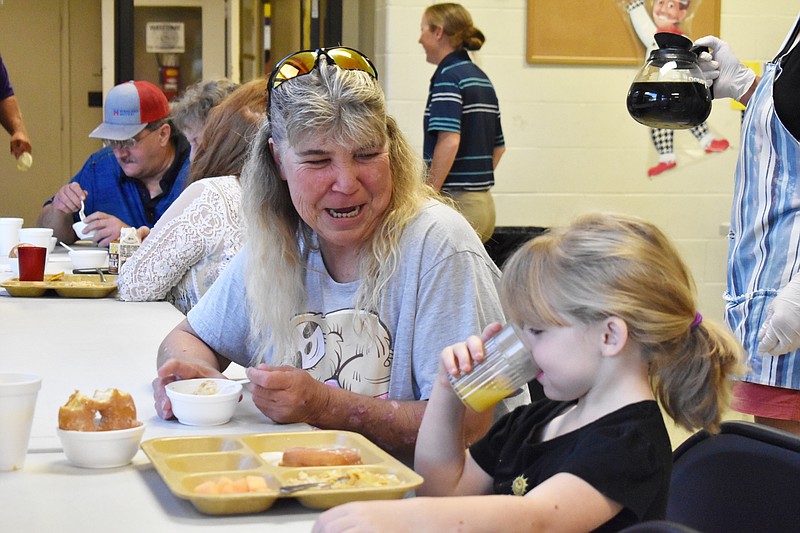 Democrat photo/Garrett Fuller — Shelley Edwards smiles as grandchild Raelynn Edwards, 5, sips on orange juice Friday (Sept. 9, 2022,) during the grandparents breakfast at Clarksburg C-II School.