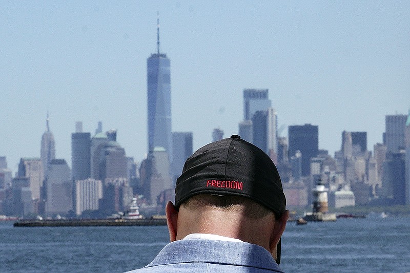 Eddie Bracken wears a cap with the word "freedom" while preparing for an interview at the Staten Island September 11th Memorial, in view of lower Manhattan, Friday, Sept. 2, 2022, in New York. Bracken, a carpenter whose sister Lucy Fishman was killed in the Sept. 11 attacks on the World Trade Center, is awaiting the trial of the attack's self-professed architect Khalid Sheik Mohammed and his co-defendants at Guantanamo. (AP Photo/Bebeto Matthews)