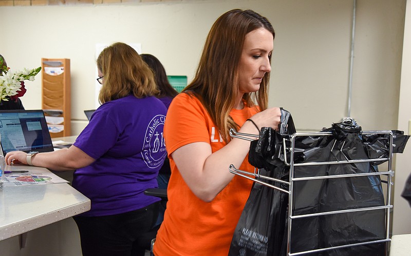 Julie Smith/News Tribune
The second day of this year's United Way Days of Caring saw employees of Public Education Employee Retirement System of Missouri volunteer at Catholic Charities food pantry. Ciara Bauer is shown here placing purchased items in a bag for the client to gather to take with them. This is the first year that the food pantry has been open in this location so it was a first time volunteer opportunity at the United Way partner agency.