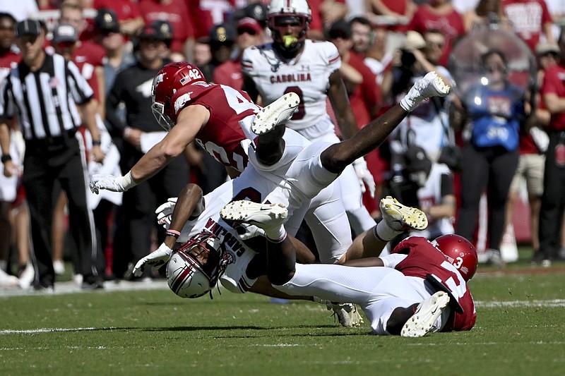 South Carolina receiver Jalen Brooks (13) is tackled by Arkansas defenders Drew Sanders (42) and Dwight McGlothern (3) during the first half of an NCAA college football game Saturday, Sept. 10, 2022, in Fayetteville, Ark. (AP Photo/Michael Woods)