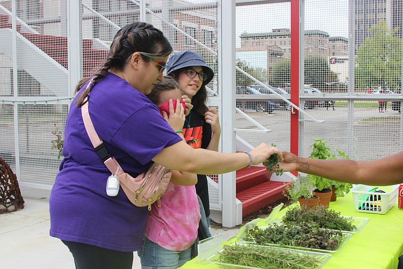 Jessica Munn (left), sisters Skarlett and Syla Munn, play the Guess the Herb game. Kourlynn Pinkins, ASC Program coordinator, manned the table. (Special to The Commercial/Deborah Horn