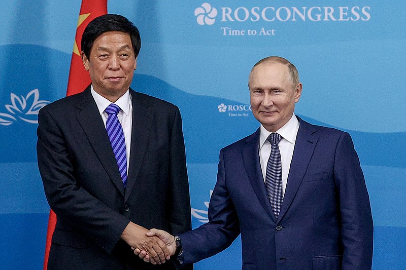 FILE - Russian President Vladimir Putin, right, and Chairman of National People's Congress Li Zhanshu pose for a photo prior to their talks on the sideline of the Eastern Economic Forum in Vladivostok, Russia, on Sept. 7, 2022. The official Xinhua News Agency said Li urged greater cooperation to fight against "external interference, sanctions and long-arm jurisdiction, among others," in a meeting with Russian lawmakers. (Egor Aleyev/TASS News Agency Host Pool Photo via AP, File)