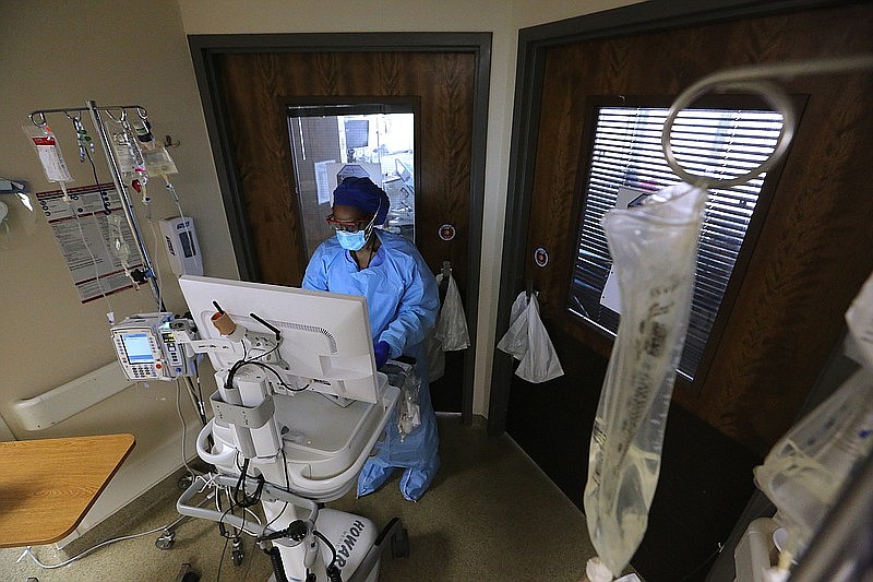 La enfermera Takela Gardner revisa el expediente de un paciente antes de ingresar a una habitación en una de las salas de COVID-19 en la Universidad de Arkansas para Ciencias Médicas el jueves, 22 de julio de 2021, en Little Rock. (Arkansas Democrat-Gazette/Thomas Metthe)