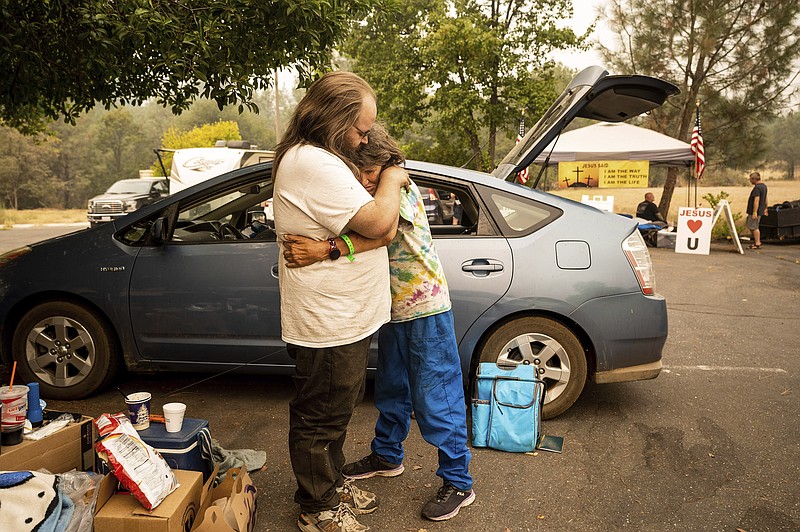 David Hance hugs mom Linda Hance outside a shelter for Mosquito Fire evacuees in Auburn, Calif., on Friday, Sept. 9, 2022. The two evacuated from their trailer near the Foresthill community. (AP Photo/Noah Berger)