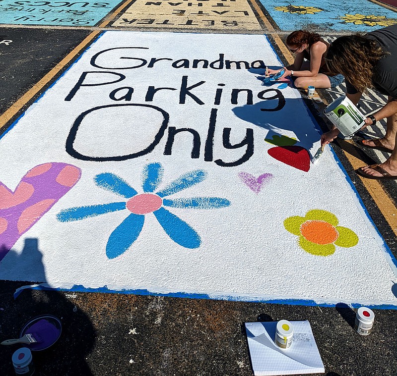 Special to the Eagle Observer/LONNIE MOLL
Keira Digby and her mother, Tina Digby, paint a parking space on the Gentry High School parking lot on Sunday. Since 2016, Students and teachers have been allowed, for a fee, to put their own design on their parking spaces for the year. The spaces are painted with paint that can be washed off with a high-pressure sprayer. The Gentry School Board, in May 2016, gave unanimous approval to a student council proposal to allow high school students to paint a design on their assigned parking spaces for a $20 fee which goes to the student council for the next homecoming dance.