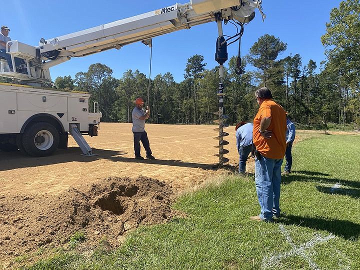 Courtesy photo
Ouachita Electric Cooperative drills holes for the scoreboard for a ball field at SAU Tech.