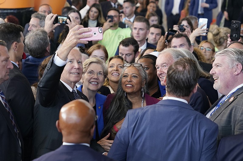 President Joe Biden takes a selfie Sen. Elizabeth Warren, D-Mass., and audience members at Boston Logan International Airport, Monday, Sept. 12, 2022, in Boston, where he delivered remarks on the Bipartisan Infrastructure Law. (AP Photo/Evan Vucci)