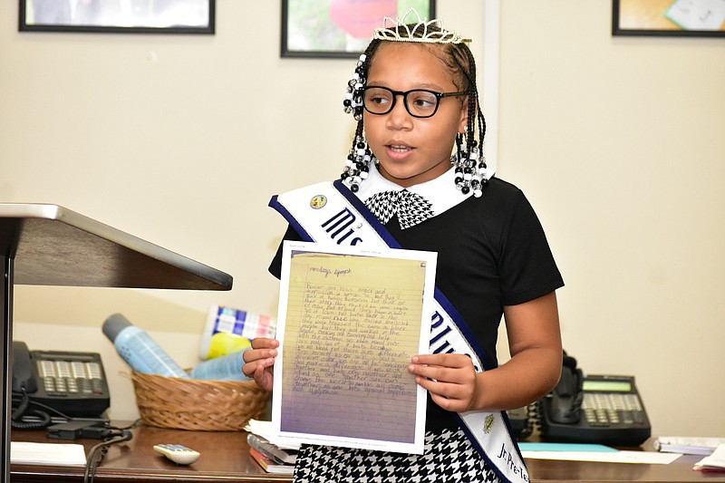 Coleman Elementary student Na'riya Ackles displays an essay she wrote while sharing an excerpt of it with Watson Chapel School Board members Monday evening. (Pine Bluff Commercial/I.C. Murrell)