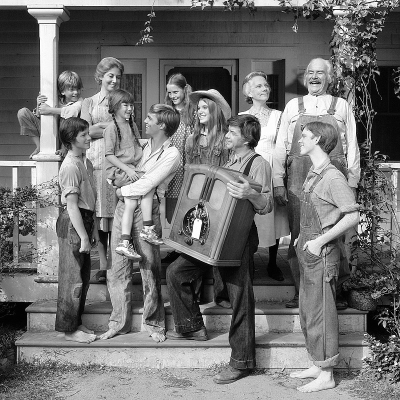 This 1974 photo provided by CBS shows, from left, David Harper, as Jim-Bob Walton; Eric Scott, as Ben Walton; Michael Learned, as Olivia Walton; Kami Cotler, as Elizabeth Walton; Richard Thomas, as John Boy Walton; Mary McDonough, as Erin Walton; Judy Norton, as Mary Ellen Walton; Ralph Waite, as John Walton; Ellen Corby, as Ester “Grandma” Walton; Will Geer, as Zeb “Grandpa” Walton; Jon Walmsley, as Jason Walton, in the television show The Waltons. (CBS Photo Archive via AP)