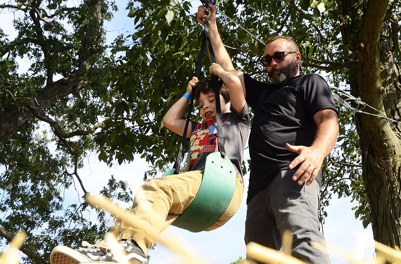 Eileen Wisniowicz/News Tribune photo: 
Doc Gue, 6, is helped onto a zipline by Kyle Bax on Friday, Sept. 16, 2022, at Rhymers Ridge in Jefferson City. The event was a part of Rhymers Ridge's soft opening for their harvest festival.