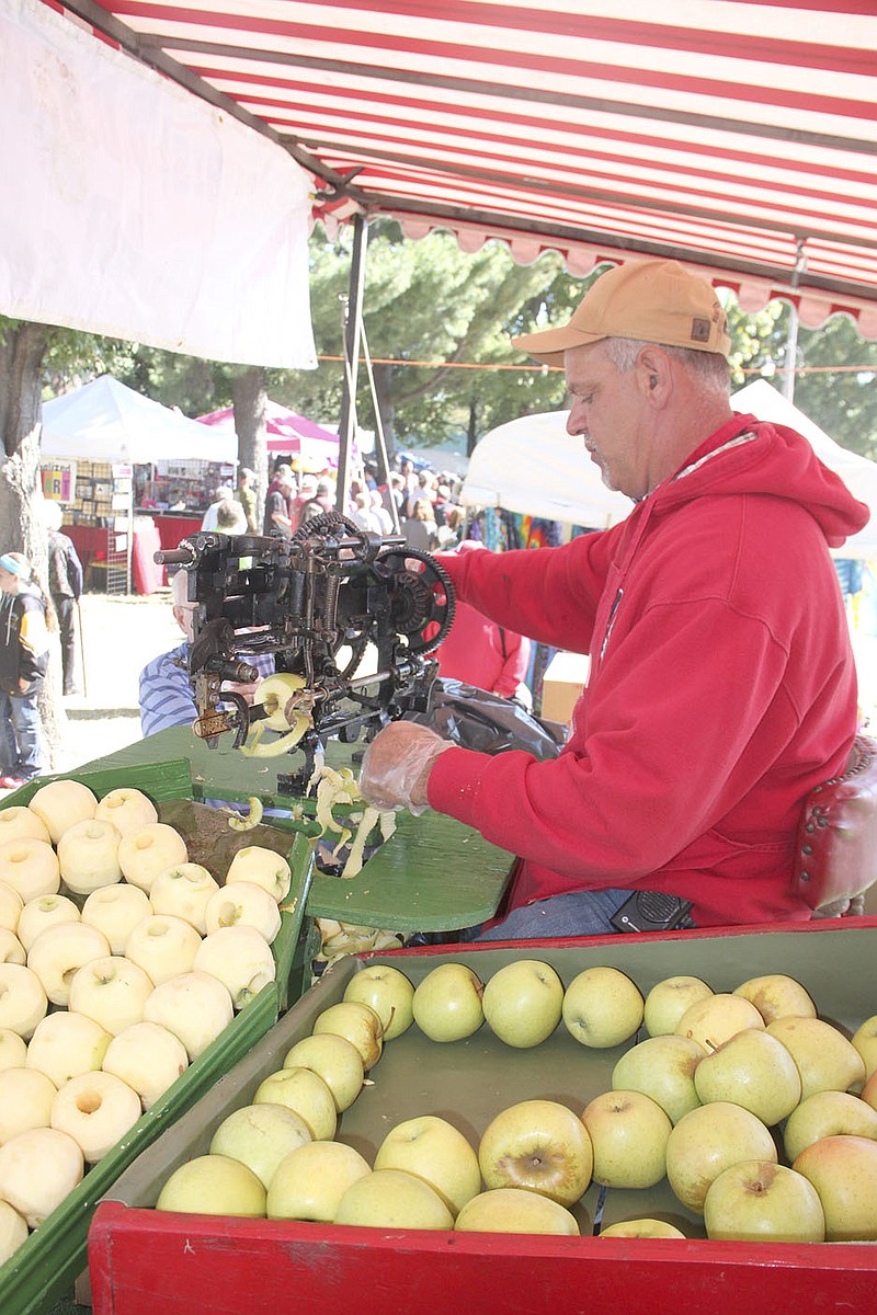 FILE PHOTO
Former Lincoln Fire Chief Willie Leming slices apples at the Arkansas Apple Festival. Leming usually can be found every year sitting in this same spot, volunteering his time.