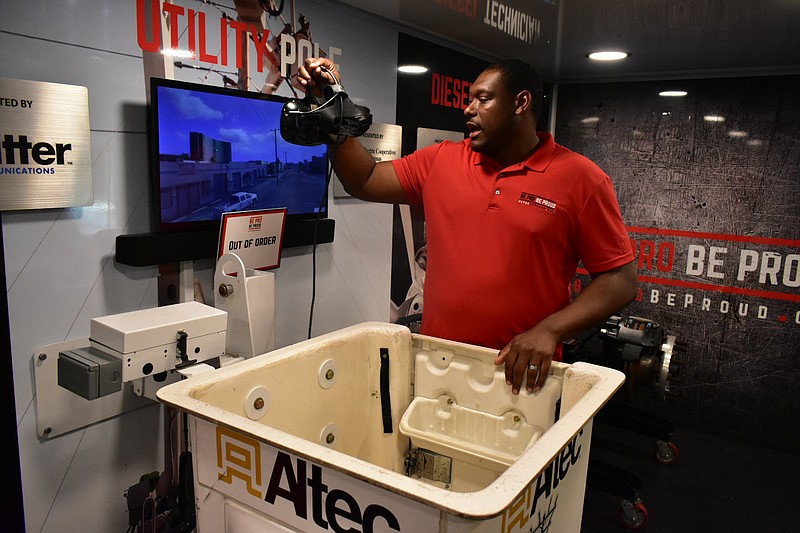 Montrell Thornton, tour manager of Be Pro Be Proud, explains how students virtually learn to work on a utility pole inside the initiative's mobile showcase. (Pine Bluff Commercial/I.C. Murrell)