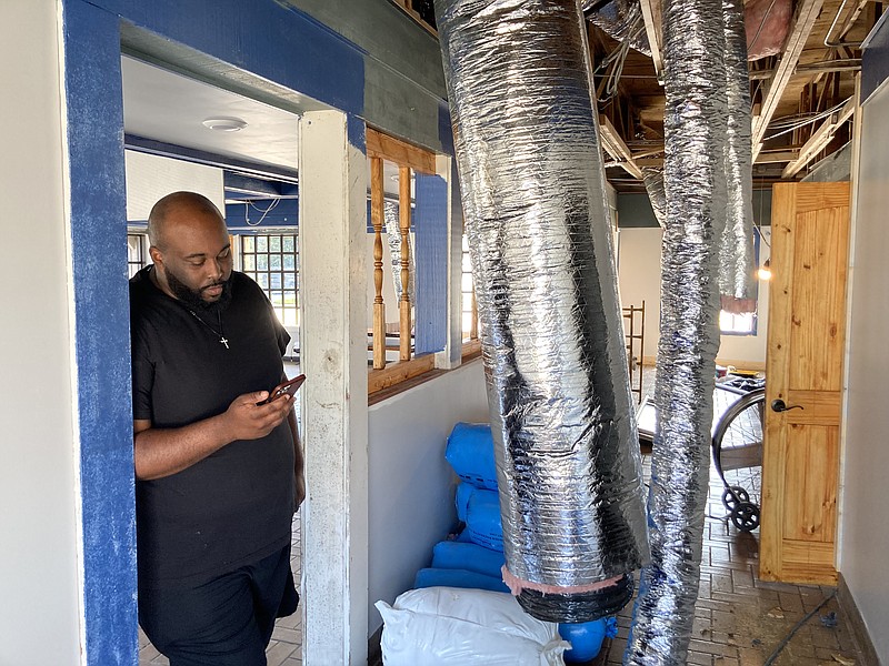 Brandon Monk searches his phone for photos of what the old Long John Silver's restaurant location looked like when he and his sister, Morgan, bought it. There's still much work to be done, but the site will be the new home of the Monks' Underwater Seafood restaurant, which is expected to open in October. (Pine Bluff Commercial/Byron Tate)
