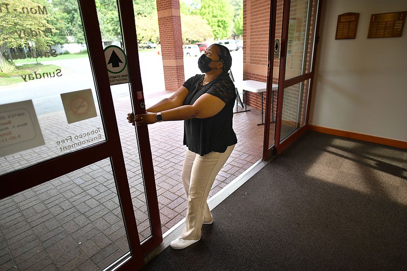 Annette Clark, a circulation clerk at the Springdale Public Library, shows the broken front automatic doors Thursday, Sept. 1, 2022, that staff must manually push open and closed during the day at the library in Springdale. The library was not included in a planned downtown rejuvenation project. Visit nwaonline.com/220904Daily/ for today's photo gallery. 
(NWA Democrat-Gazette/Andy Shupe)