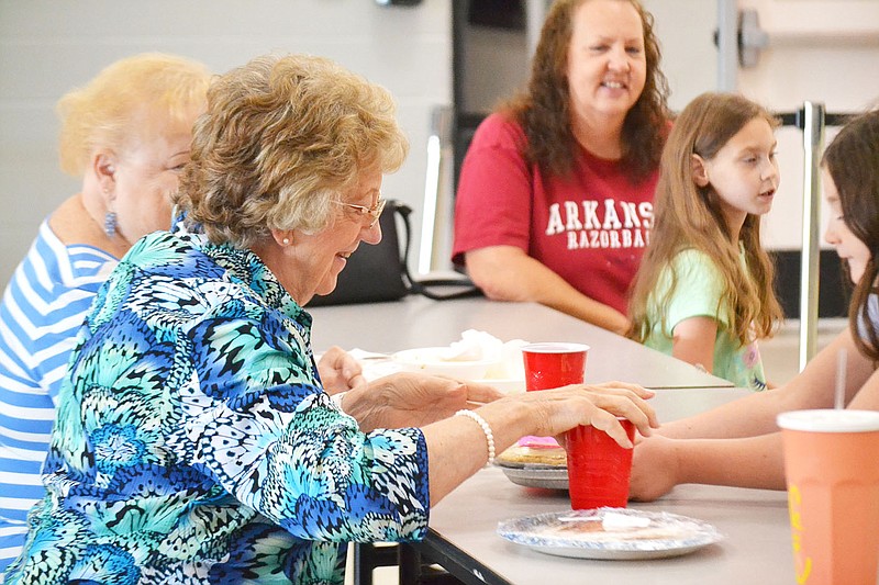 TIMES photographs by Annette Beard
Sandy Herzberg, front center, is delighted at winning a pie during the Pea Ridge Alumni Association dinner and pie auction Saturday.