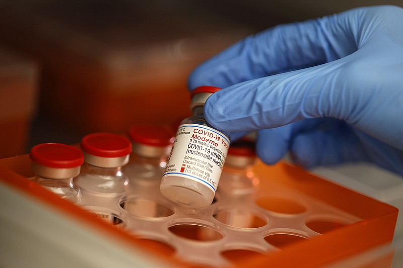 A healthcare worker selects a vial of the Moderna vaccine on Dec. 2, 2021. MUST CREDIT: Bloomberg photo by Michaela Handrek-Rehle.