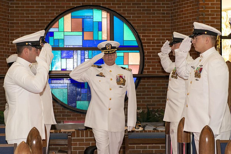 Capt. John Cage, outgoing commodore of Submarine Squadron Twenty, salutes the side boys during a change of command ceremony held at the chapel onboard Naval Submarine Base Kings Bay, Georgia. (U.S. Navy photo by Ashley Berumen)