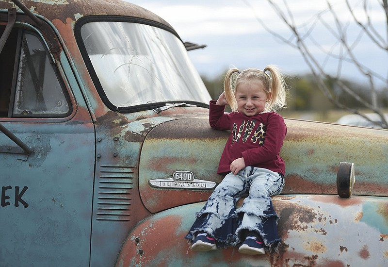 File photo NWA Democrat-Gazette/Charlie Kaijo Lydia Montgomery, 5, sits on a truck as she poses for pictures, Oct. 15, 2020, at the Benton County Fairgrounds in Bentonville.