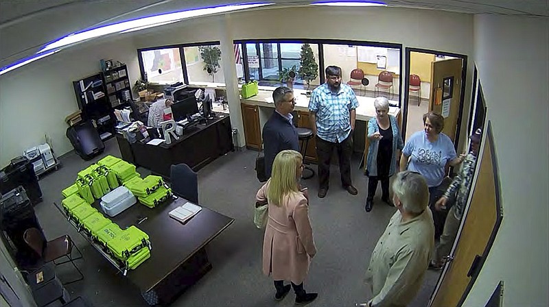 This Jan. 7, 2021, image taken from Coffee County, Ga., security video, appears to show Cathy Latham (center, long turquoise top), introducing members of a computer forensic team to local election officials. Latham was the county Republican Party chair at the time. The computer forensics team was at the county elections office in Douglas, Ga., to make copies of voting equipment in an effort that documents show was arranged by Sidney Powell and others allied with then-President Donald Trump. (Coffee County, Georgia via AP)