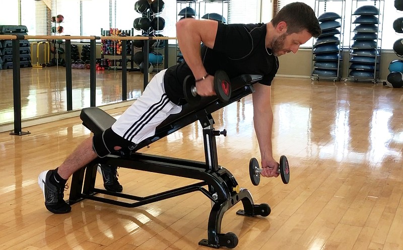 Josh Holt, fitness director of Little Rock Racquet Club, demonstrates the Dumbbell Piston Row for Matt Parrott's Master Class. (Arkansas Democrat-Gazette/Celia Storey)