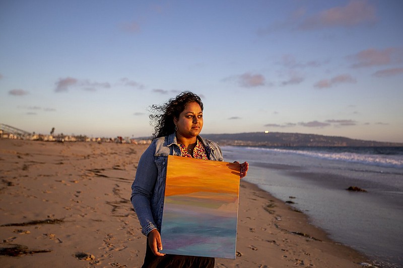 Sandhya Kambhampati, a data reporter on the Los Angeles Times Data Desk, holds a painting she did while coping with long Covid. She goes to the Strand at Hermosa Beach each week to take in the fresh air and sometimes paint. Photo taken in Hermosa Beach on Sept. 14, 2022. (Allen J. Schaben/Los Angeles Times/TNS)