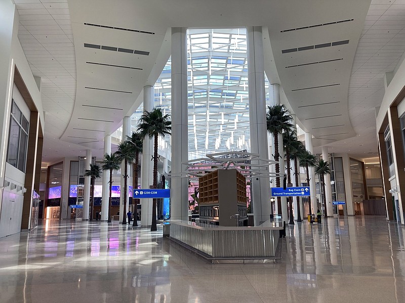 Artificial palm trees line and skylights are seen in the new terminal at Orlando International Airport, Tuesday, Sept. 6, 2022 in Orlando, Fla. The addition of Terminal C gives the airport the ability to handle an additional 12 million passengers at the terminal's 15 new gates. (AP Photo/Mike Schneider)