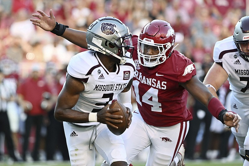 Arkansas defensive lineman Jordan Domineck (14) prepares to sack Missouri State quarterback Jason Shelly (3) during the first half of an NCAA college football game Saturday, Sept. 17, 2022, in Fayetteville, Ark. (AP Photo/Michael Woods)