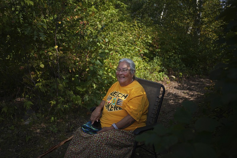 Elaine Fleming, a Leech Lake Band of Ojibwe elder and professor at the Leech Lake Tribal College, smiles as she watches her students learn to hand-process the wild rice gathered on Leech Lake, Monday, Sept. 12, 2022, in Cass Lake, Minn. "In our origin story, we were told to go where food grew on water," said Fleming. "It's our sacred food." (AP Photo/Jessie Wardarski)