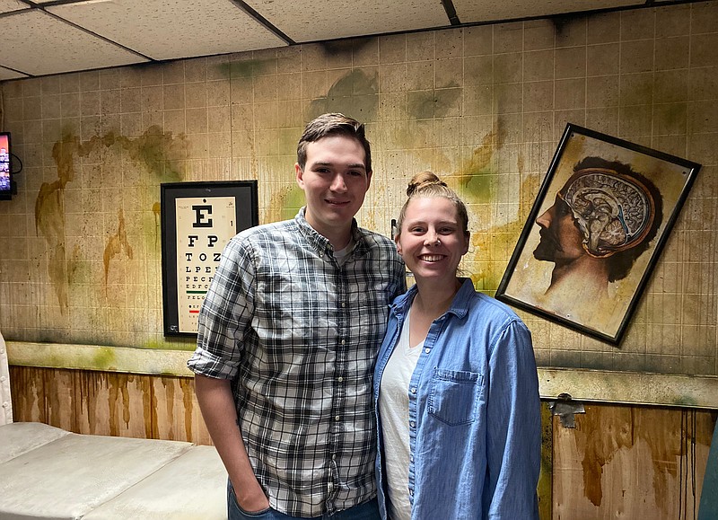 Chris and Rilee Perlingiero pose in the "Virus" room at their business, Capital Escape. The business contains several escape rooms with different themes and puzzles to be solved. (News Tribune/Cameron Gerber photo)