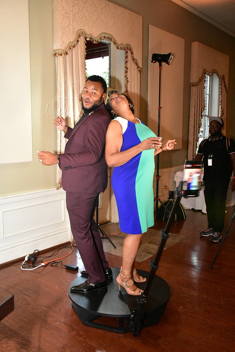 A smartphone on a 360-degree video booth whirls around Jamal Gordon and Debra Jones. (Pine Bluff Commercial/I.C. Murrell)