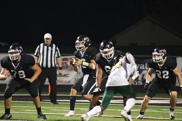 White Hall's Noah Smith drops back for a pass on Friday night during the Bulldogs game against Mills. (Special to The Commercial/Jamie Hooks)