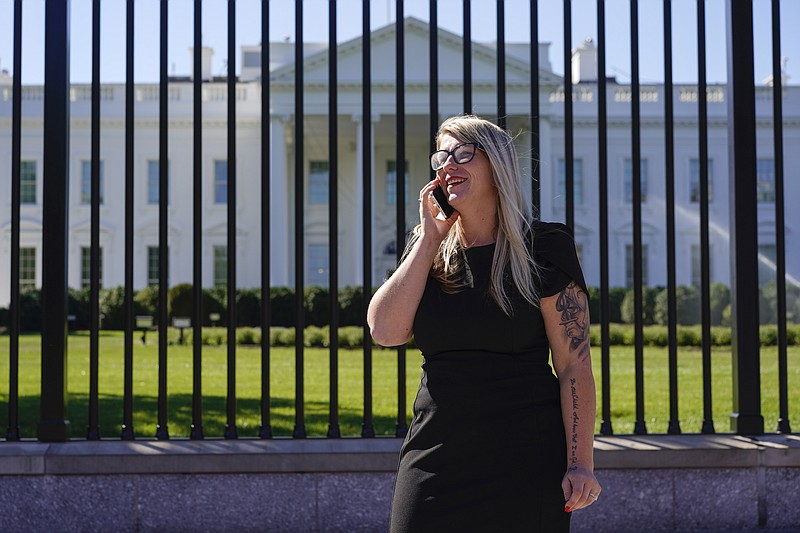 Courtney Allen an organizer for Mobilize Recovery and on the settlement advisory council for the state of Maine, talks on her cell on Pennsylvania Avenue in front of the White House in Washington, Friday, Sept. 23, 2022. Allen and others are in Washington to meet with Doug Emhoff, husband of Vice President Kamala Harris, to give their recommendations for the distribution of the federal settlement money as billions of dollars in opioid lawsuit settlements are starting to flow to governments. (AP Photo/Carolyn Kaster)