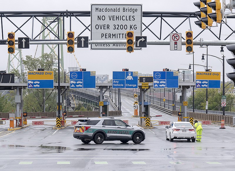 Police block lanes of traffic as both Halifax harbor bridges were closed in Dartmouth, N.S. on Saturday, Sept. 24, 2022. Strong rains and winds lashed the Atlantic Canada region as Fiona closed in early Saturday as a big, powerful post-tropical cyclone, and Canadian forecasters warned it could be one of the most severe storms in the country's history. (Andrew Vaughan /The Canadian Press via AP)