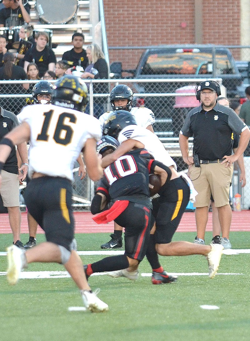 Staff photograph by Annette Beard
Prairie Grove Tiger defender No. 2 stopped Blackhawk junior Caden Thompson, No. 10, after Thompson caught a pass and headed for the end zone Friday, Sept. 23, 2022, in Blackhawk Stadium in the Pea Ridge Homecoming game.