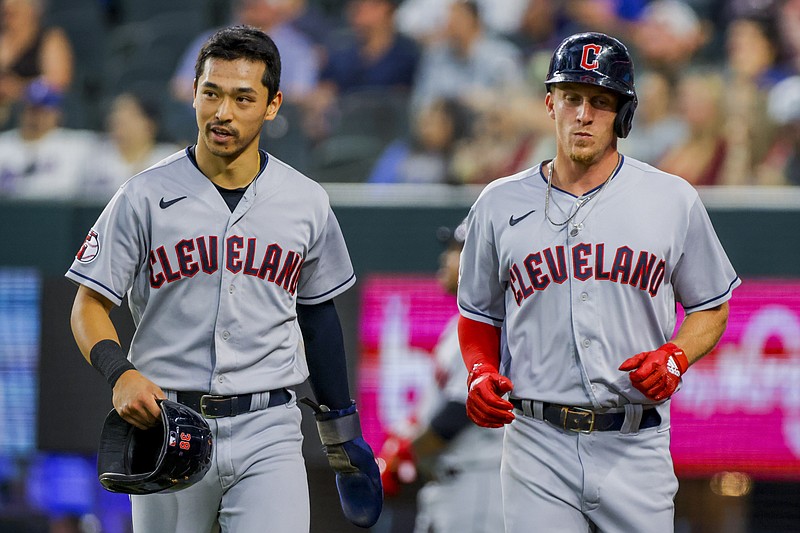 Cleveland Guardians outfielders Steven Kwan, left, and Myles Straw, right, walk to the dugout together after scoring on a Texas Rangers throwing error during the third inning of a baseball game in Arlington, Texas on Sunday, Sept. 25, 2022. (AP Photo/Gareth Patterson)