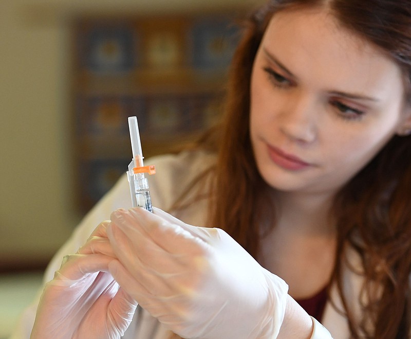 Pharmacist Kara High of Springdale prepares a flu shot Monday Nov. 13, 2017 during a free flu shot clinic at Wedington Place Apartments in Fayetteville. Walgreens on Wedington Drive sponsored the flu clinic for seniors at the complex. (NWA Democrat-Gazette/J.T. WAMPLER)