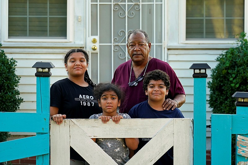 Angelo Bernard, who lives near the Denka Performance Elastomer Plant, poses with his grandchildren who are visiting him for the weekend, at his home Friday, Sept. 23, 2022, in Reserve, La. From left are Korinne Bernard, 11, Karmen Bernard, 9, and Anthony Bernard, 10, who used to attend Fifth Ward Elementary until Hurricane Ida forced them to move. "I feel for the kids that have to go to school that close to the plant," Angelo Bernard said. (AP Photo/Gerald Herbert)