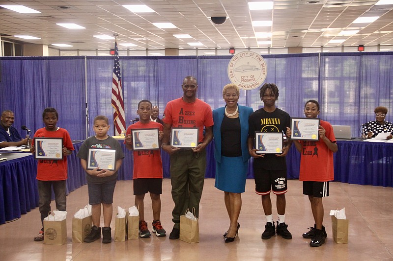 Four of the 11 boxers who participated are pictured with their coach Dominique Azeez and Pine Bluff Mayor Shirley Washington, who recognized them for their success during a summer boxing tournament. (Pine Bluff Commercial/Eplunus Colvin)