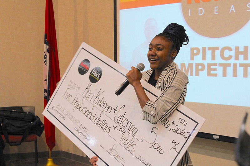 Zakari Smith, owner of Kari in the Kitchen and Catering Co., accepts a $5,000 grant from ReMix Ideas following a "Shark Tank" style pitch competition on Monday evening at the South Arkansas Community College Library. Read more about the pitch competition in Sunday's Living section of the News-Times. (Caitlan Butler/News-Times)