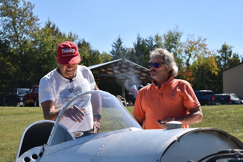 Democrat photo/Garrett Fuller — Robbie Rimel, right, of California, looks as Dennis Brooks, of Independence, points out something in the cockpit of Rimel's homemade single-seat airplane Saturday (Sept. 24, 2022,) at Phillips Field airport near California.