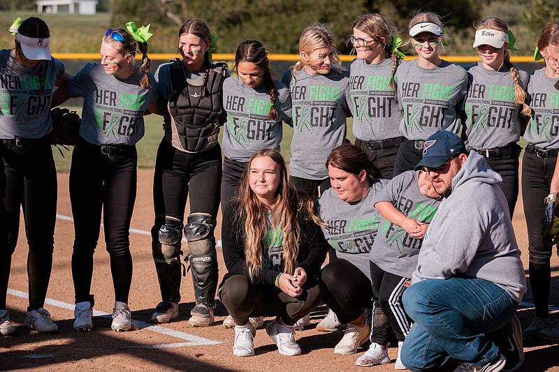 Fulton's softball gathers around Southern Boone softball player Brooklyn Smith and her family Monday at Fulton's softball field in Fulton. Smith was recently diagnosed with Non-Hodgkin's lymphoma; the Hornets gave Smith a softball and $2,900 check before the game. (Courtesy/Shawley Photography)