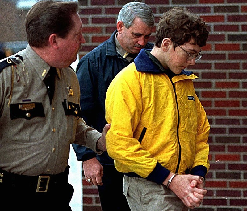 FILE - Heath High School shooting suspect Michael Carneal is escorted out of the McCracken County Courthouse after his arraignment in Paducah, Ky., Jan. 15, 1998. Carneal was accused of opening fire inside a Kentucky high school, killing three classmates and wounding five others Dec. 1, 1997. In the quarter century that has passed, school shootings have become a depressingly regular occurrence in the U.S. Carneal's parole hearing in September 2022 raises questions about the appropriate punishment for children who commit heinous crimes. Even if they can be rehabilitated, many wonder if it is fair to the victims for them to be released. (Sam Upshaw Jr./Courier Journal via AP)