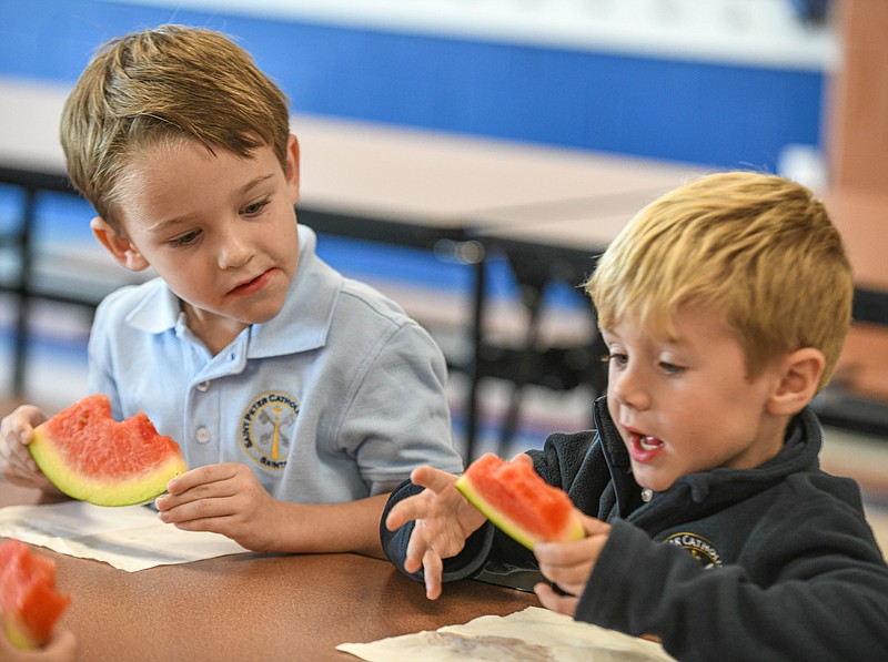 Julie Smith/News Tribune photo: 
Maddex, at right, and Ben, enjoy a slice of watermelon Tuesday, Sept. 27, 2022, following a visit by Kim Fischer of Fischer Farms in north Jefferson City. The boys are in kindergarten at St. Peter Interparish School where the lunchroom is provided locally grown watermelon from the nearby farm.